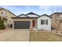 Inviting home featuring stone accents, a dark garage door, and a vibrant red front door at 4391 Mcmurdo Ct, Castle Rock, CO 80108
