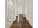 Bright hallway with wood floors, white walls, and a front door visible at the end at 4391 Mcmurdo Ct, Castle Rock, CO 80108