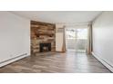 Bright living room includes modern floors, stone fireplace, and access to a balcony with natural light at 10150 E Virginia Ave # 7-204, Denver, CO 80247
