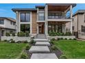Stunning modern home featuring stone accents, expansive windows, and a beautifully landscaped front yard at 220 Glencoe St, Denver, CO 80220
