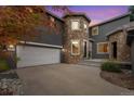 Stunning exterior featuring a stone turret, attached garage, and a paved driveway at 2832 Danbury Ave, Highlands Ranch, CO 80126