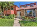 Inviting home exterior featuring a well-manicured lawn, brick accents, and a welcoming front entrance at 6225 E Mississippi Ave, Denver, CO 80224