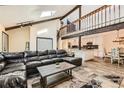 Open-concept living space with vaulted ceiling, wooden beams, and seamless access to the kitchen and dining areas at 6225 E Mississippi Ave, Denver, CO 80224