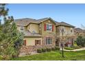 Two-story home featuring stone accents, red shutters, and manicured landscaping at 15496 W 66Th Dr # G, Arvada, CO 80007