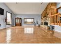 Spacious living room with tiled floors, a stone fireplace, and ample natural light from large windows at 1632 S County Road 137, Bennett, CO 80102