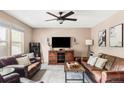 Cozy living room featuring plush leather sofas, a stylish media center, and a modern ceiling fan at 4619 S Tabor Way, Morrison, CO 80465