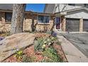 Close up of front yard showcasing colorful flowers and brick facade at 4655 Independence St # 3, Wheat Ridge, CO 80033