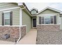 Close up view of the front entrance, showcasing stone accents and walkway at 16516 Fairbanks Rd, Platteville, CO 80651