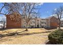 Exterior view of the building with well-maintained lawn and mature tree, creating an inviting atmosphere at 10150 E Virginia Ave # 4-104, Denver, CO 80247