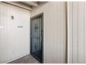 View of secure front door with metal grate and wooden paneling at 10150 E Virginia Ave # 4-104, Denver, CO 80247