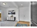Bright entryway features wood flooring, a stylish cabinet, modern art, and a front door at 5147 N Waco St, Denver, CO 80249