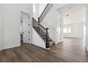 Bright entryway featuring hardwood floors and a staircase with elegant wood railing and white risers at 25214 E Warren Pl, Aurora, CO 80018