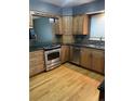 Well-equipped kitchen featuring stainless steel appliances, wood cabinets, and granite countertops at 12381 E Vassar Dr, Aurora, CO 80014