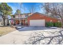 A two-story red brick home with an attached two-car garage and concrete driveway at 5158 W Lake Pl, Littleton, CO 80123
