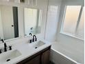 Bright bathroom features a double sink vanity, a shower-tub combination, and white tile at 19033 E 22Nd Cir, Aurora, CO 80011