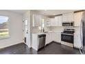 Modern kitchen boasts stainless steel appliances, white cabinets, and ample counter space at 19033 E 22Nd Cir, Aurora, CO 80011
