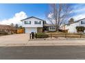 Inviting home featuring mature trees, a well-manicured lawn, and a spacious driveway at 3411 S Olathe Way, Aurora, CO 80013