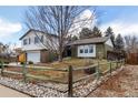 Landscaped split-level home with manicured lawn, trees, and a charming wooden fence at 3411 S Olathe Way, Aurora, CO 80013