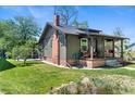Side exterior of home with brick foundation and chimney, lush lawn, and covered porch at 4321 Winona Ct, Denver, CO 80212