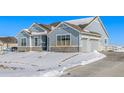 Two-story house with gray siding, stone accents and attached two-car garage at 16122 Emporia Way, Brighton, CO 80602