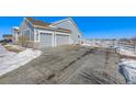 Two-car garage with gray doors and ample driveway space at 16122 Emporia Way, Brighton, CO 80602