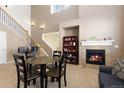 Living room with a fireplace, staircase, and an adjacent dining area at 3454 Cascina Pl # D, Highlands Ranch, CO 80126