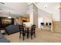 Open floor plan living room with staircase, high ceiling, and adjacent kitchen at 3454 Cascina Pl # D, Highlands Ranch, CO 80126