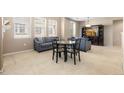 Open living room area featuring neutral carpeting, gray sofas, and large windows at 3454 Cascina Pl # D, Highlands Ranch, CO 80126