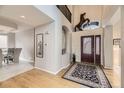Bright foyer with hardwood floors, a high ceiling, and an elegant horse sculpture over the front door at 1312 Pine View Rd, Golden, CO 80403