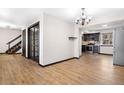 Open living space with hardwood floors, leading to the kitchen and staircase, showcasing modern design at 1456 S Jasper St, Aurora, CO 80017