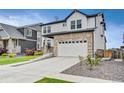 Charming two-story home features a stone facade, white siding, and a spacious two-car garage at 17276 E 103Rd Ave, Commerce City, CO 80022