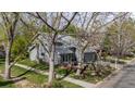 Charming gray home with mature trees, green lawn, a small patio, and well-maintained landscaping at 7126 Cedarwood Cir, Boulder, CO 80301