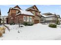 Two-story house with snow-covered front yard and driveway at 1128 Starglow Pl, Highlands Ranch, CO 80126