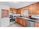 Galley kitchen with wood cabinets and stainless steel appliances at 360 Linda Ln, Denver, CO 80221