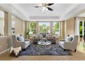 Bright living room features large windows, a ceiling fan and comfortable seating arrangement at 4821 Bluegate Dr, Highlands Ranch, CO 80130