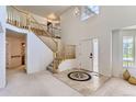 Bright foyer with soaring ceilings, decorative tile inlay, and wooden staircase at 11803 E 114Th Pl, Commerce City, CO 80640