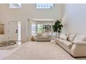 Spacious living room featuring high ceilings, large windows, and open entry way at 11803 E 114Th Pl, Commerce City, CO 80640