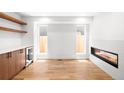 Bright living room boasts hardwood floors, built-in shelving, a wine fridge, and a modern fireplace at 4131 Osage St, Denver, CO 80211
