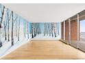 Bright living room features wood floors, a balcony, and a beautiful mural that brings the outdoors inside at 955 Eudora St # 1106, Denver, CO 80220