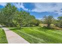 Well-manicured lawn in a neighborhood park with walking paths, mature trees, and beautiful landscaping at 22580 E Ontario Dr # 202, Aurora, CO 80016