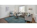 Cozy living room featuring a plush rug, comfortable seating, and hardwood floors at 14881 E 117Th Ave, Commerce City, CO 80603