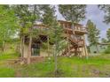 Backyard view featuring a wooden deck, a yard, and an exterior sliding glass door at 9209 William Cody Dr, Evergreen, CO 80439