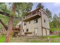 Exterior side view featuring multiple wooden decks, a two-car garage, and wooden siding at 9209 William Cody Dr, Evergreen, CO 80439
