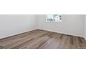 Bright bedroom with modern, light-colored wood flooring and ample natural light from a window at 19040 E 96Th Pl, Commerce City, CO 80022