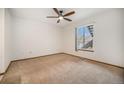 A bedroom is bright and spacious, with carpet, a ceiling fan, and a large window at 8025 W Eastman Pl # 2-102, Lakewood, CO 80227