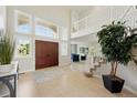 Bright foyer boasts large windows, double doors, tile flooring, and a staircase to the upper level at 9556 Kemper Dr, Lone Tree, CO 80124