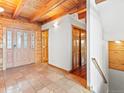 Inviting entryway with tile floors, wood ceiling beams, and wooden doors at 11766 Coal Creek Heights Dr, Golden, CO 80403