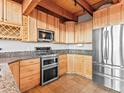 Well-equipped kitchen with granite countertops, stainless steel appliances, and wood cabinets at 11766 Coal Creek Heights Dr, Golden, CO 80403