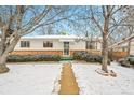 Charming single Gathering home with brick accents and a pathway to the front door at 6512 Upham St, Arvada, CO 80003