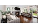 Cozy living room with a fireplace, built-in shelves, and sliding glass doors to the backyard at 5265 S Cathay Way, Centennial, CO 80015